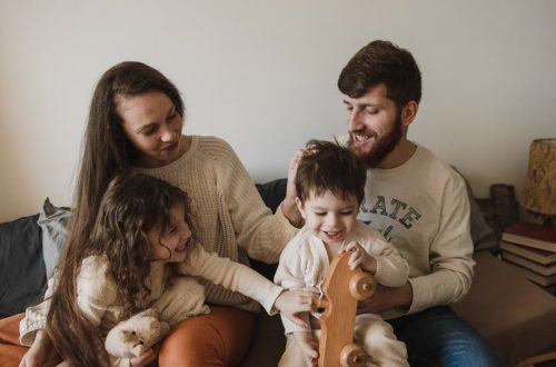 A joyful family of four sitting together on a sofa, enjoying their time with toys.